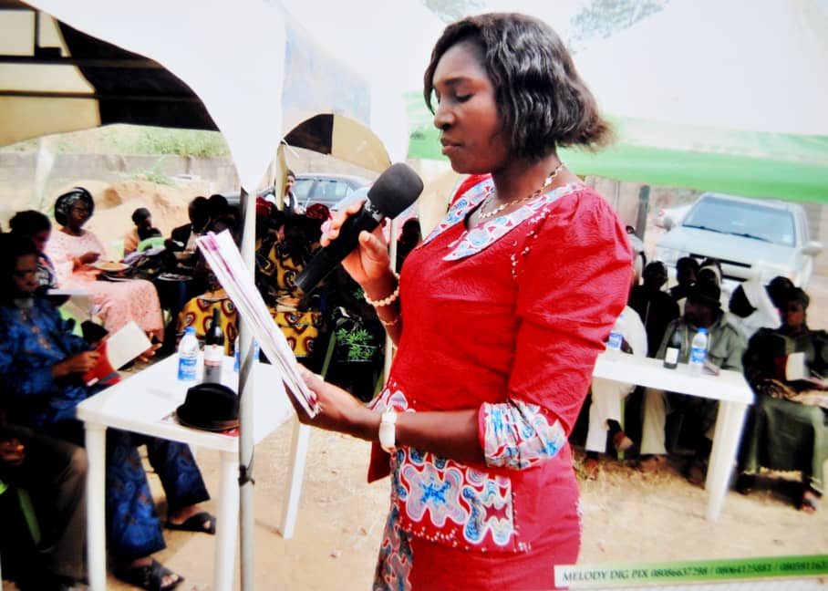 Woman speaking at an outdoor community gathering