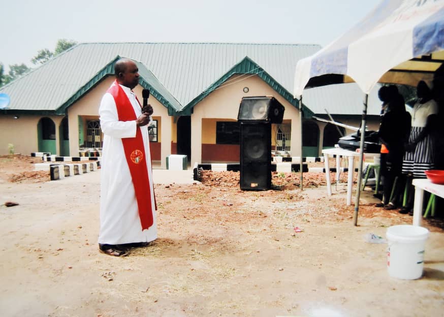A man speaking outdoors beside a building
