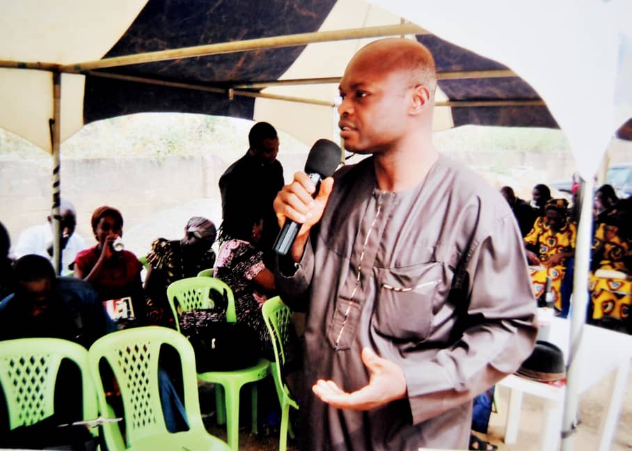 A man speaking to people at an outdoor gathering
