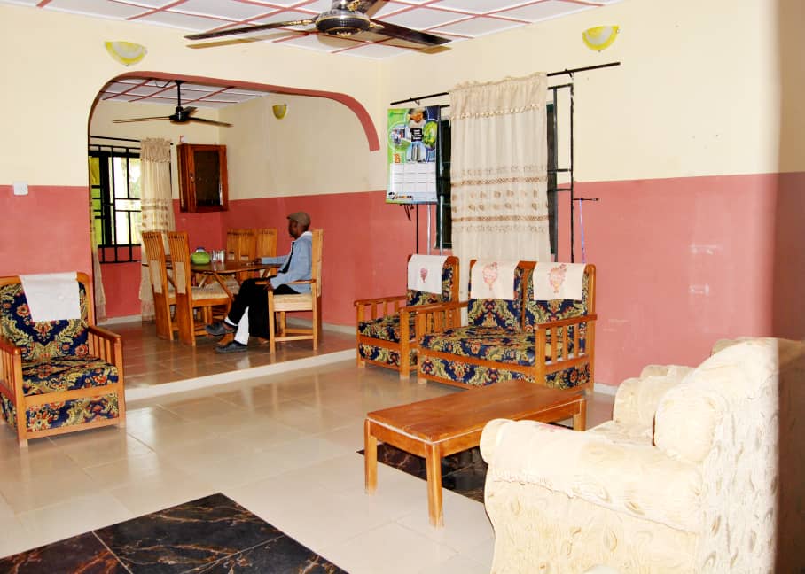 A furnished interior lounge with a seated adult in the background