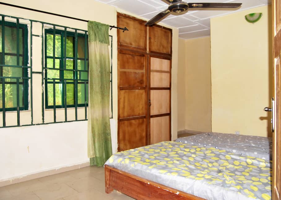 A bedroom with a bed, wardrobe and window